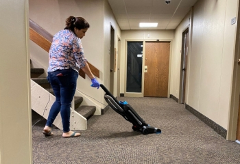 Women Operating A Vacuum Cleaner In the Hallway